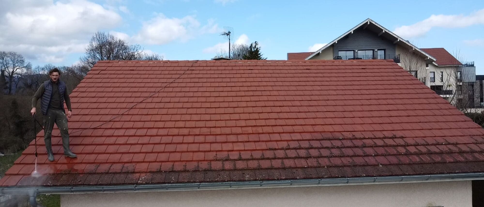 Toiture en tuile nettoyée par PROUX, avec vue sur les montagnes du Pays de Gex